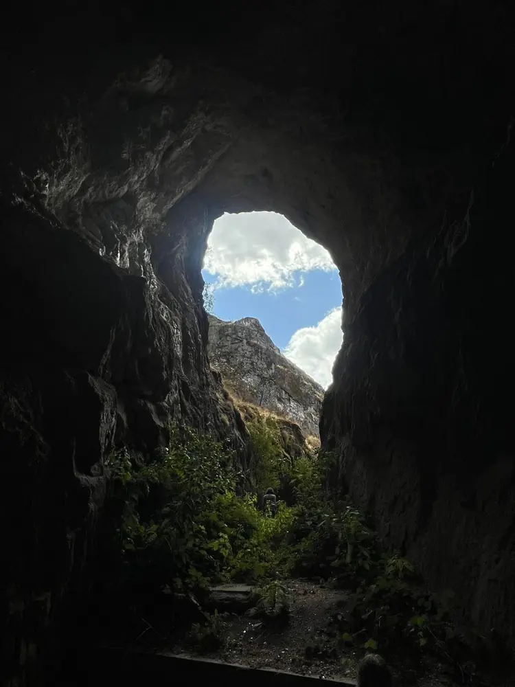 Looking out from inside the crystal mine towards a rocky peak and blue sky