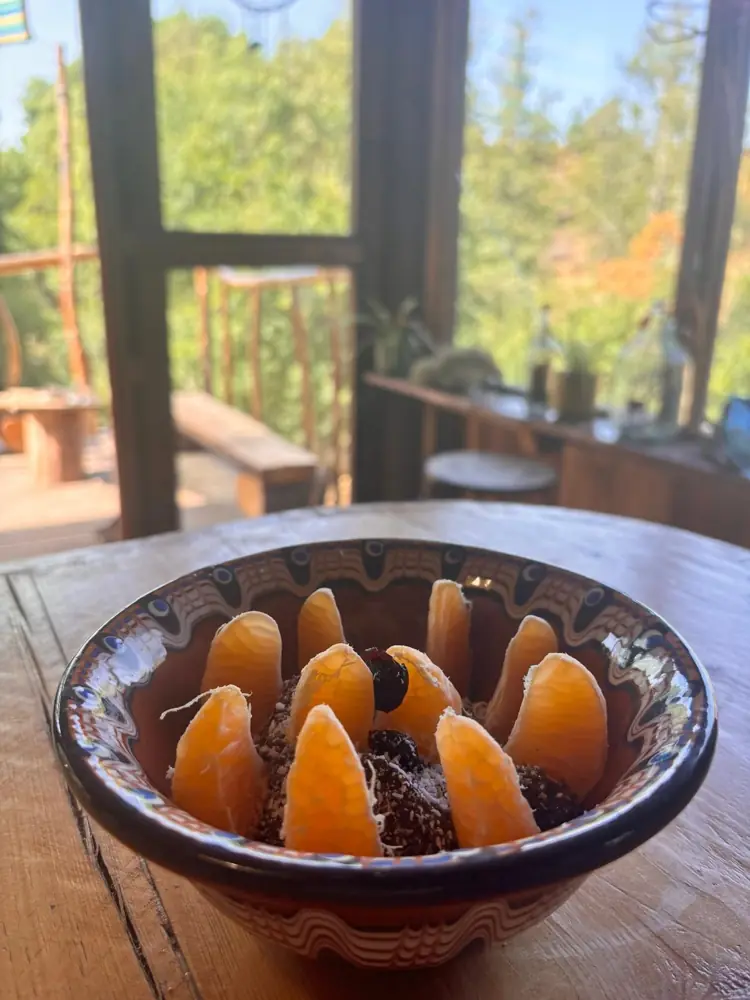 A morning chia bowl topped with orange slices, with the valley through the open windows