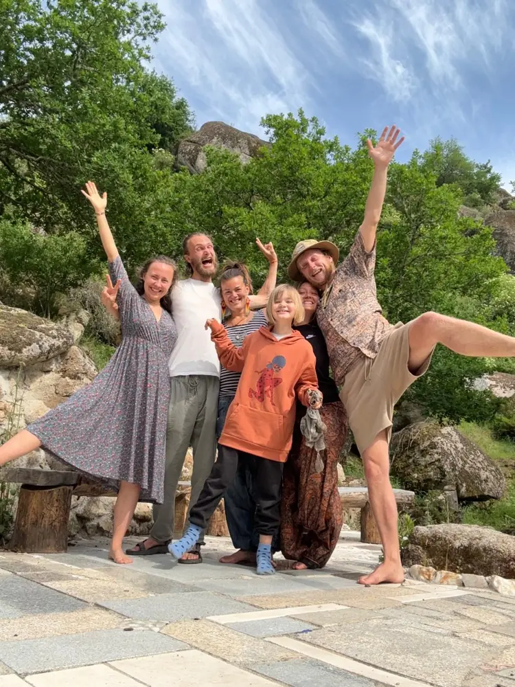 A group of guests and team cheering with arms in the air on a stone terrace in the valley